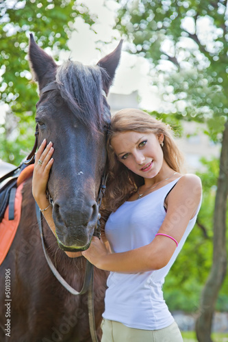 Portrait of a young girl with a horse. Focus on horses face. © lenkusa