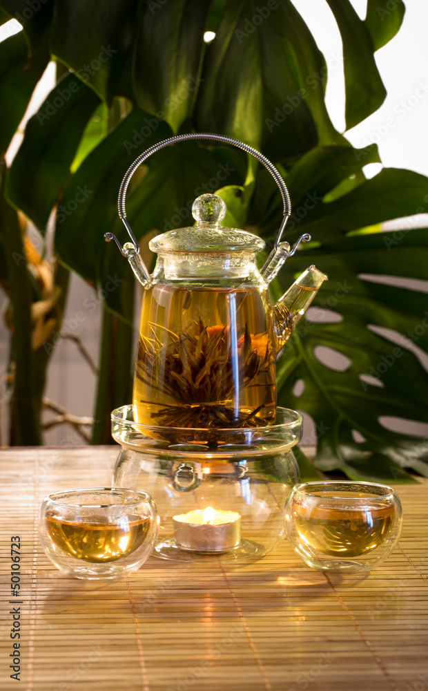 Chinese teapot with tea, on a burning support from glass