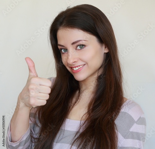 Young woman with thumb up. Ok sign. Closeup portrait