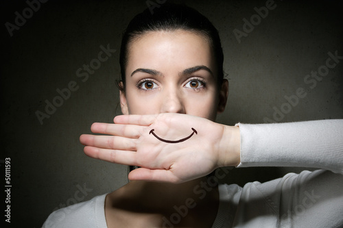 young girl crying with her hand covering her mouth photo