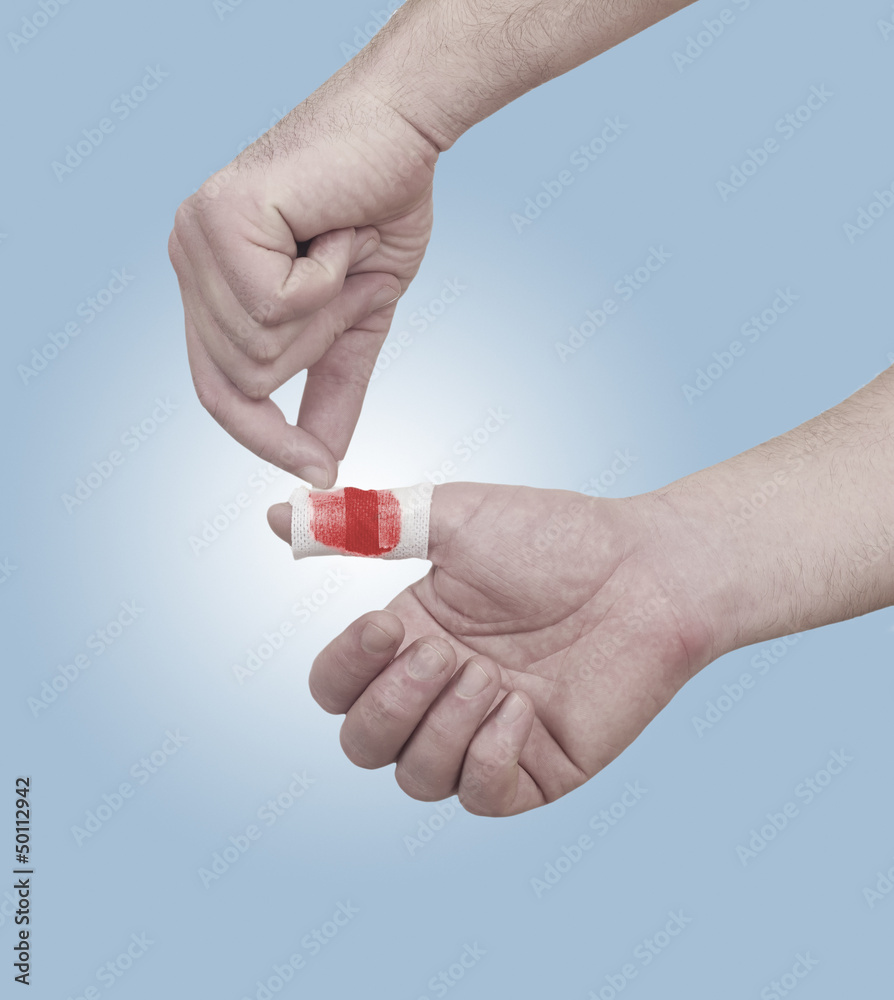 A person medically dressed with a cotton ball and bandage over a A person medically dressed with a cotton ball and bandage over a