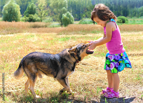 Happy little girl playing with dog © vvvita