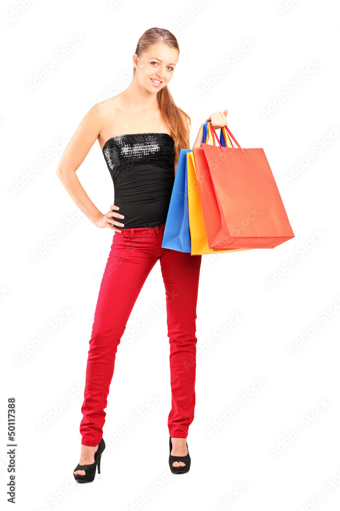 Full length portrait of a young smiling female holding shopping