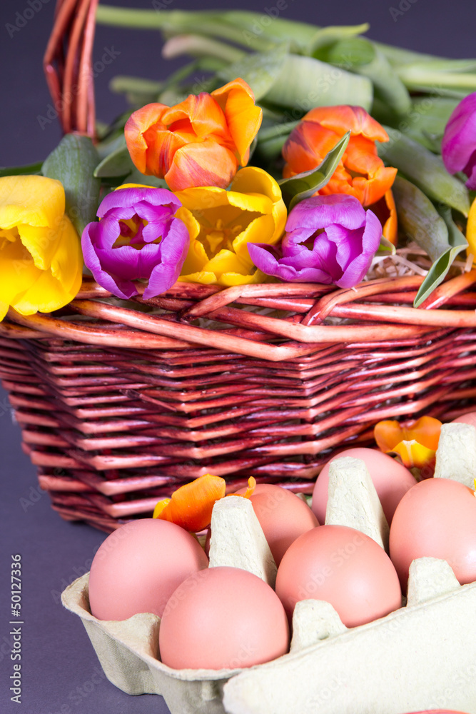 brown basket with colorful tulips and eggs brown basket with colorful tulips and eggs