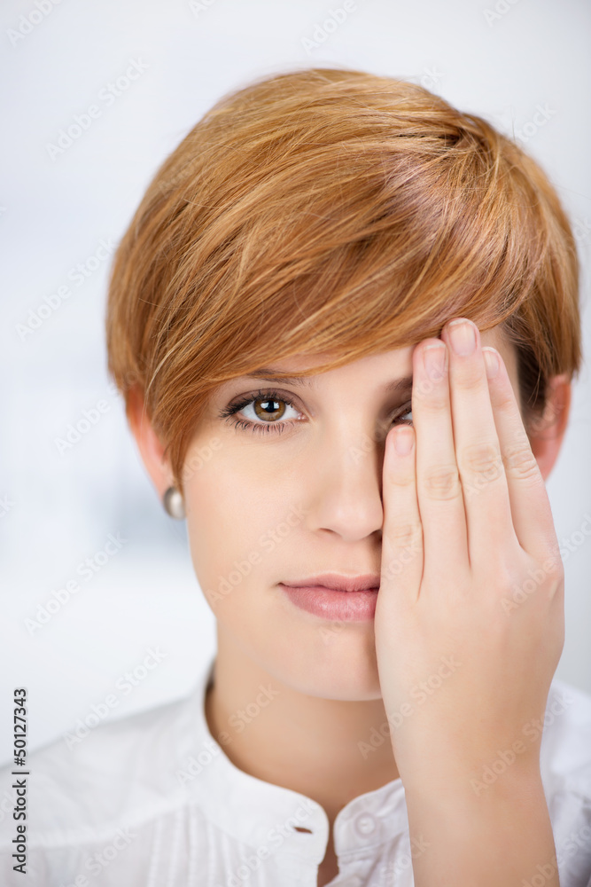 junge frau hält ein auge zu