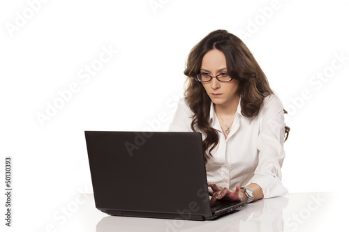concentrated girl at work on a laptop on white background