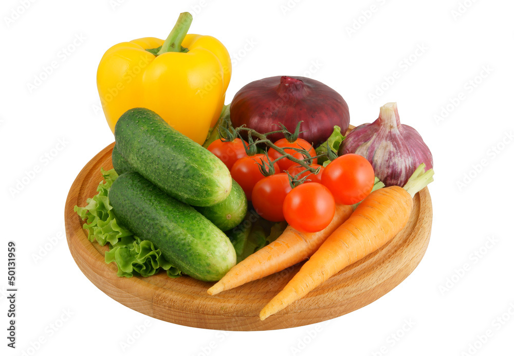 Vegetables on wooden cutting board isolated on white Vegetables on wooden cutting board isolated on white