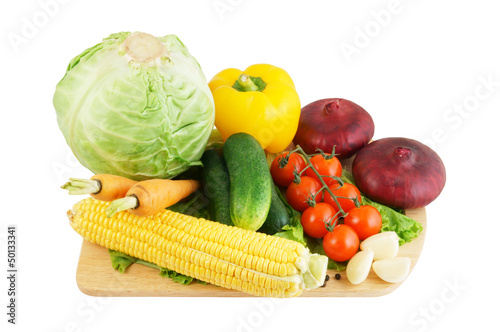Vegetables on wooden cutting board isolated on white