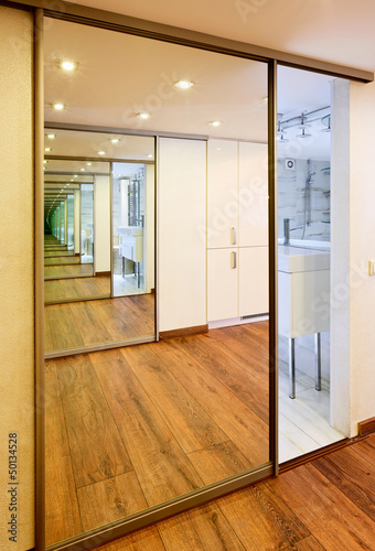 Sliding-door mirror wardrobe in modern hall interior with infini