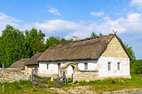 A typical antique Ukrainian country house with a thatch roof, in Pirogovo near Kiev © Maxal Tamor