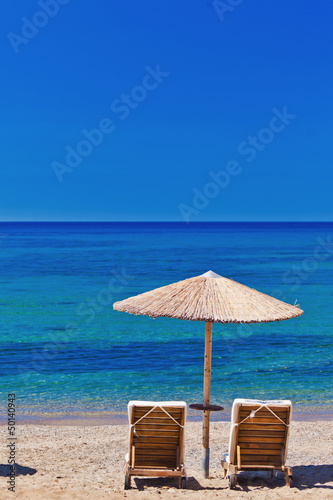 view of the beach with chairs and umbrellas