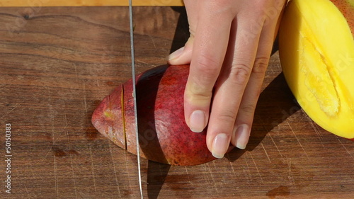 woman hand slice ripe ecologic mango fruit knife wooden board