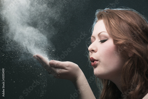 The girl blows off a dust from a palm