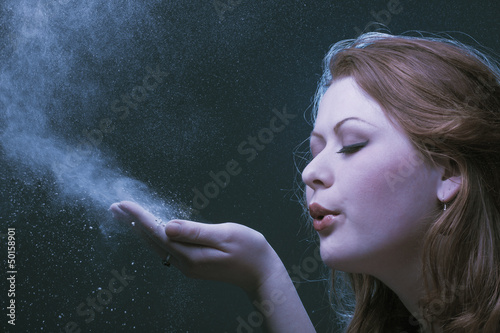 The girl blows off a dust from a palm