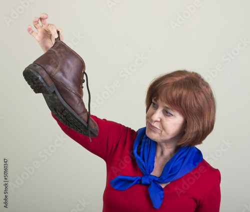 Bild auf Leinwand Unhappy woman holding a dirty shoe.