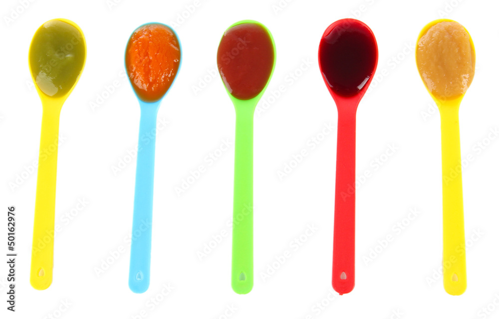 Baby puree in spoons isolated on white Baby puree in spoons isolated on white