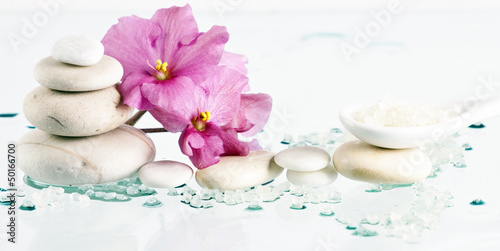 Spa stones and pink flower on white