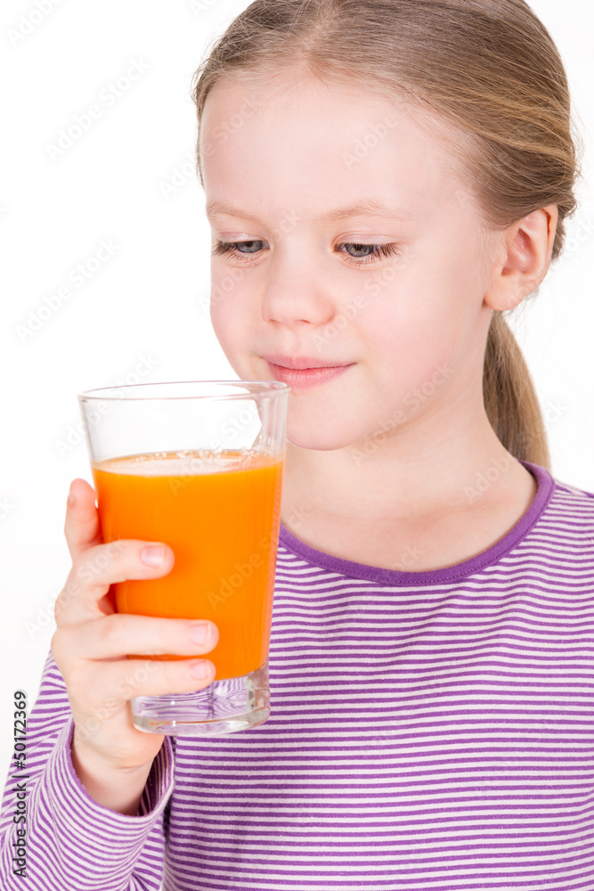Young, smiling child looking and drinking orange juice Young, smiling child looking and drinking orange juice