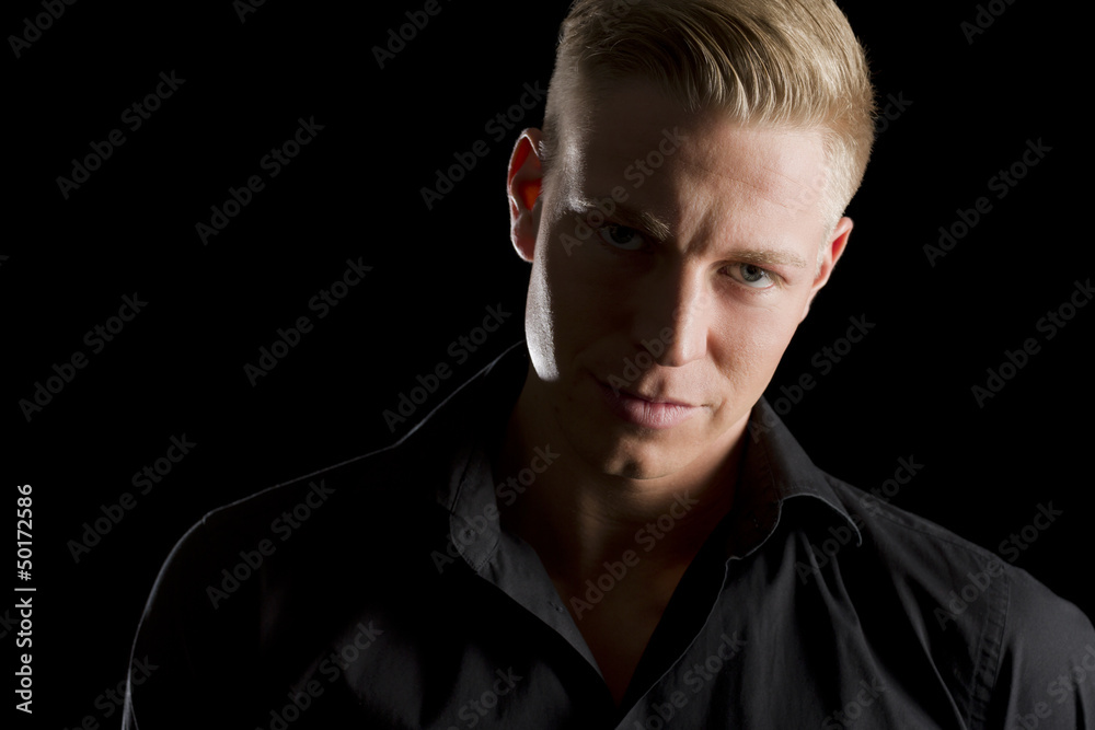 Obraz premium Low key portrait of young alluring man looking straight.