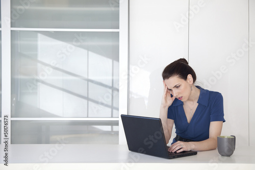 Caucasian businesswoman using laptop at desk