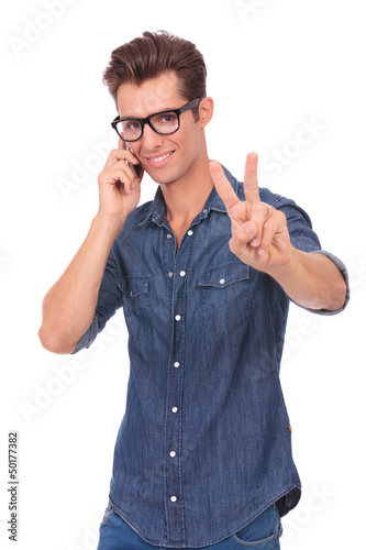 man on phone shows victory sign