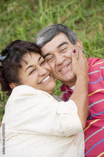 Smiling Hispanic couple hugging