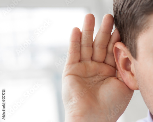 A man holds his hand to the ear