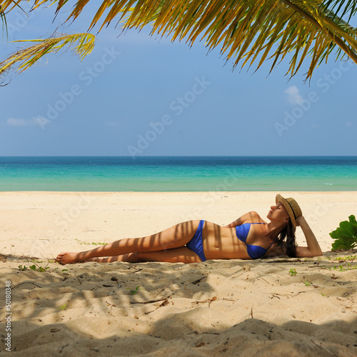 Woman at beach under palm tree