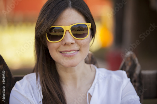 Pretty young woman wearing sunglasses and smiling