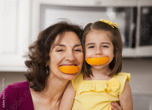 Caucasian grandmother and granddaughter eating fruit photo