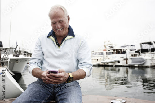 Man using cell phone in marina