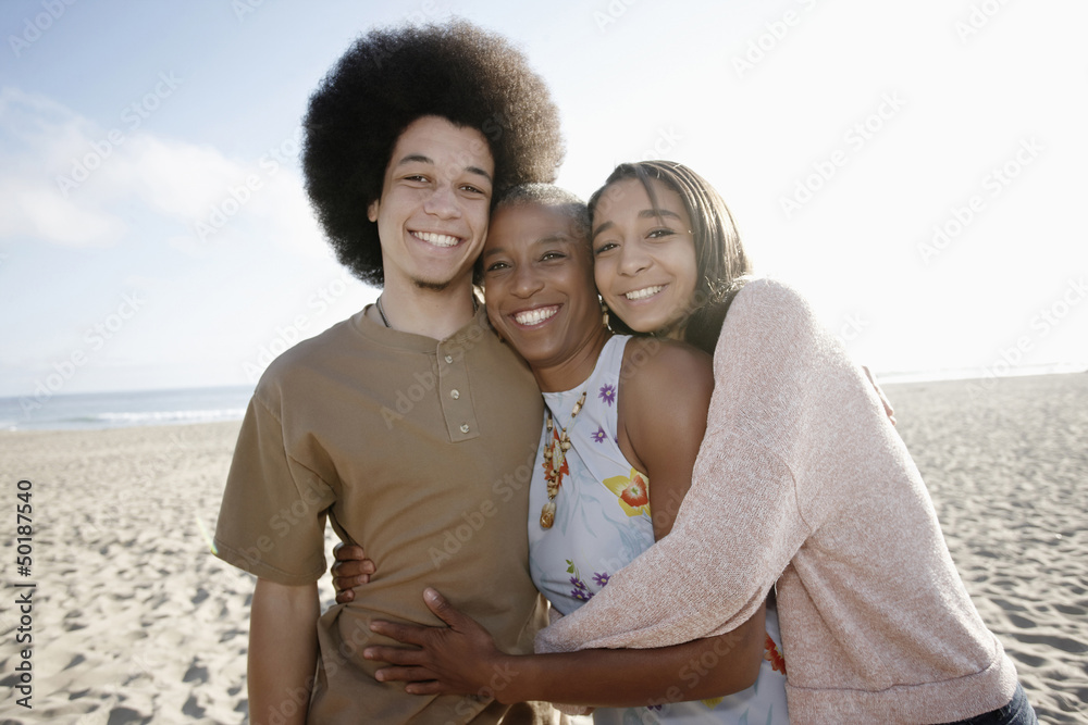 Mother and children hugging on beach Mother and children hugging on beach