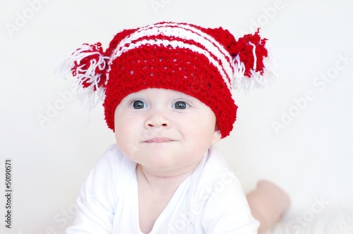 Portrait of the funny baby in red knitted hat