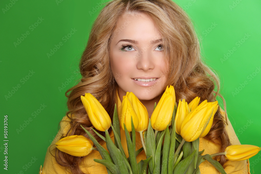 Happy smiling girl with spring-flower yellow tulips isolated on