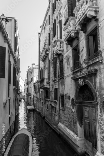 Black and white Venice channel with aged ruined buildings © eldeiv