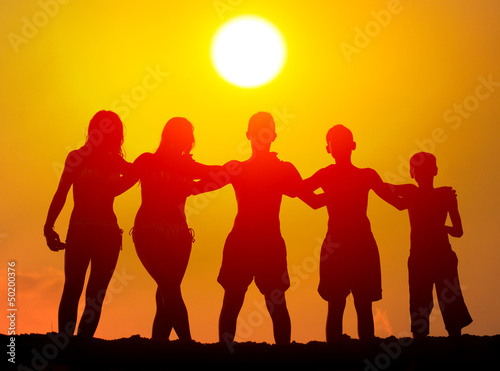 Silhouettes of boys and girls hugging on the beach