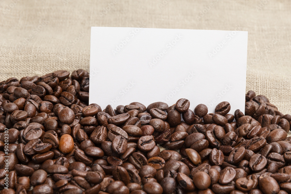 heap of coffee beans on burlap with card heap of coffee beans on burlap with card