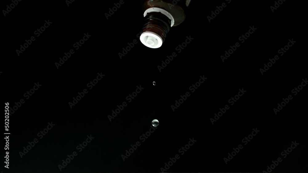 Medicine dripping from bottle on black background Medicine dripping from bottle on black background