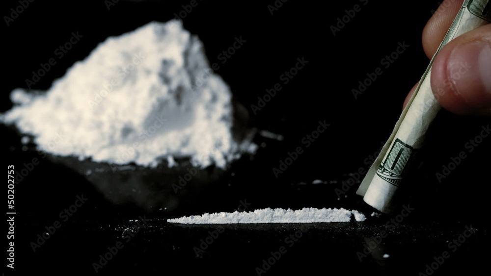 Someone snorting a line of cocaine beside a large pile Stock ...
