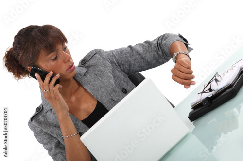 businesswoman talking on her cell and looking at her watch