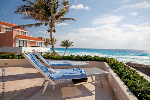 Two Sunbathing Chairs toward the Ocean