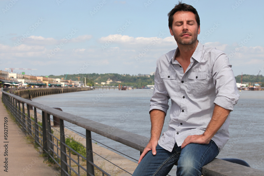 Man sitting by river. Man sitting by river.