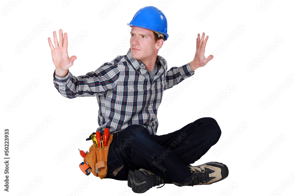 craftsman sitting cross-legged on the floor hands up craftsman sitting cross-legged on the floor hands up