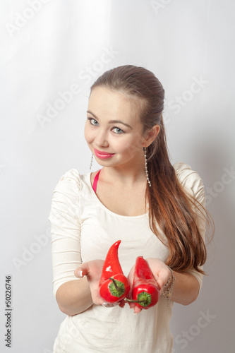 young blond woman with red peppers on white