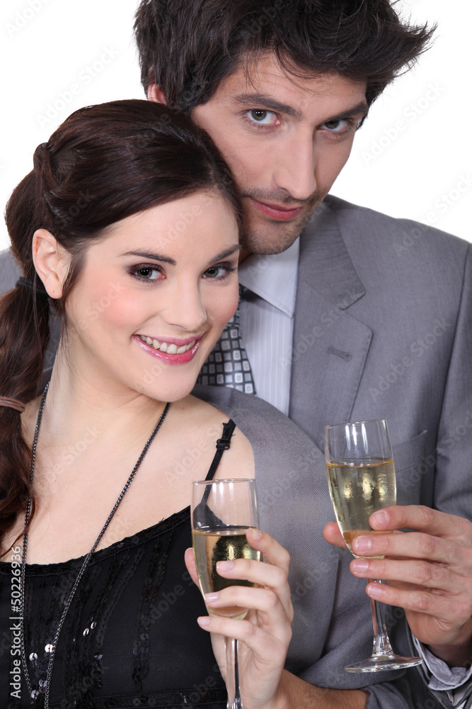 Young man and woman smiling holding champagne glasses Young man and woman smiling holding champagne glasses