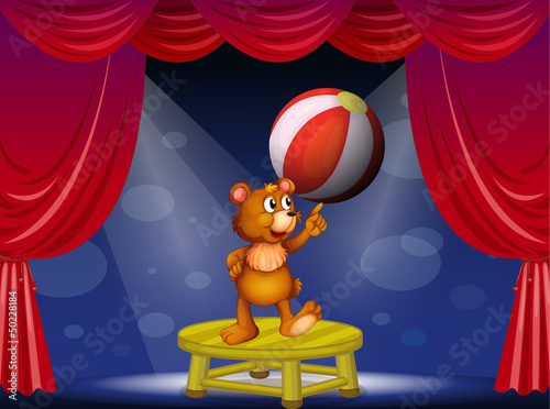 A bear balancing the ball with his finger