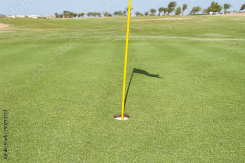 Base of flag pole on golf green