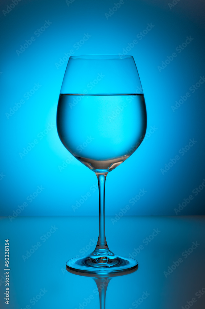 Glass with water on a blue background