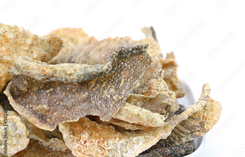 Crispy fried fish skin with spices on white background