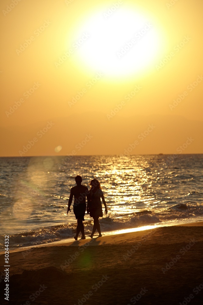 Silhouette of love couple walking on beach